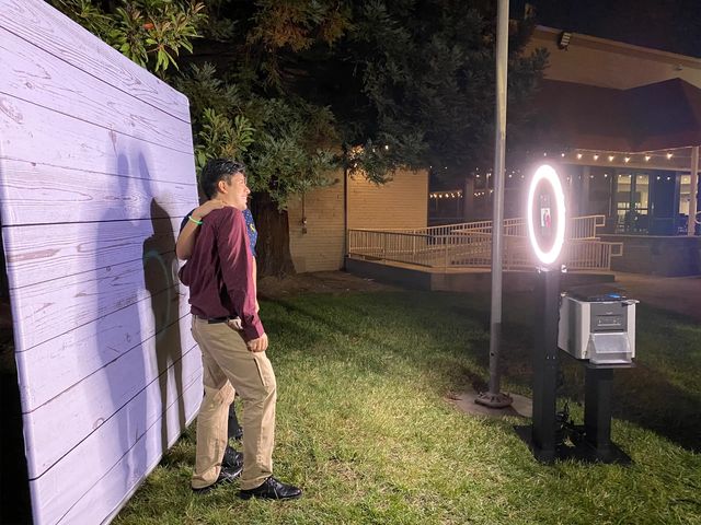 Ring light photo booth glowing at an evening garden event