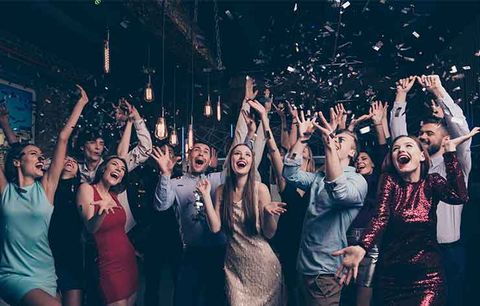 Guests dancing under colorful event lighting